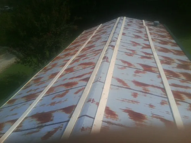 Rusted metal roof panels with new wood purlins before replacement — Storm Damage Roof Repair in Kawkawlin by Roofing Brothers