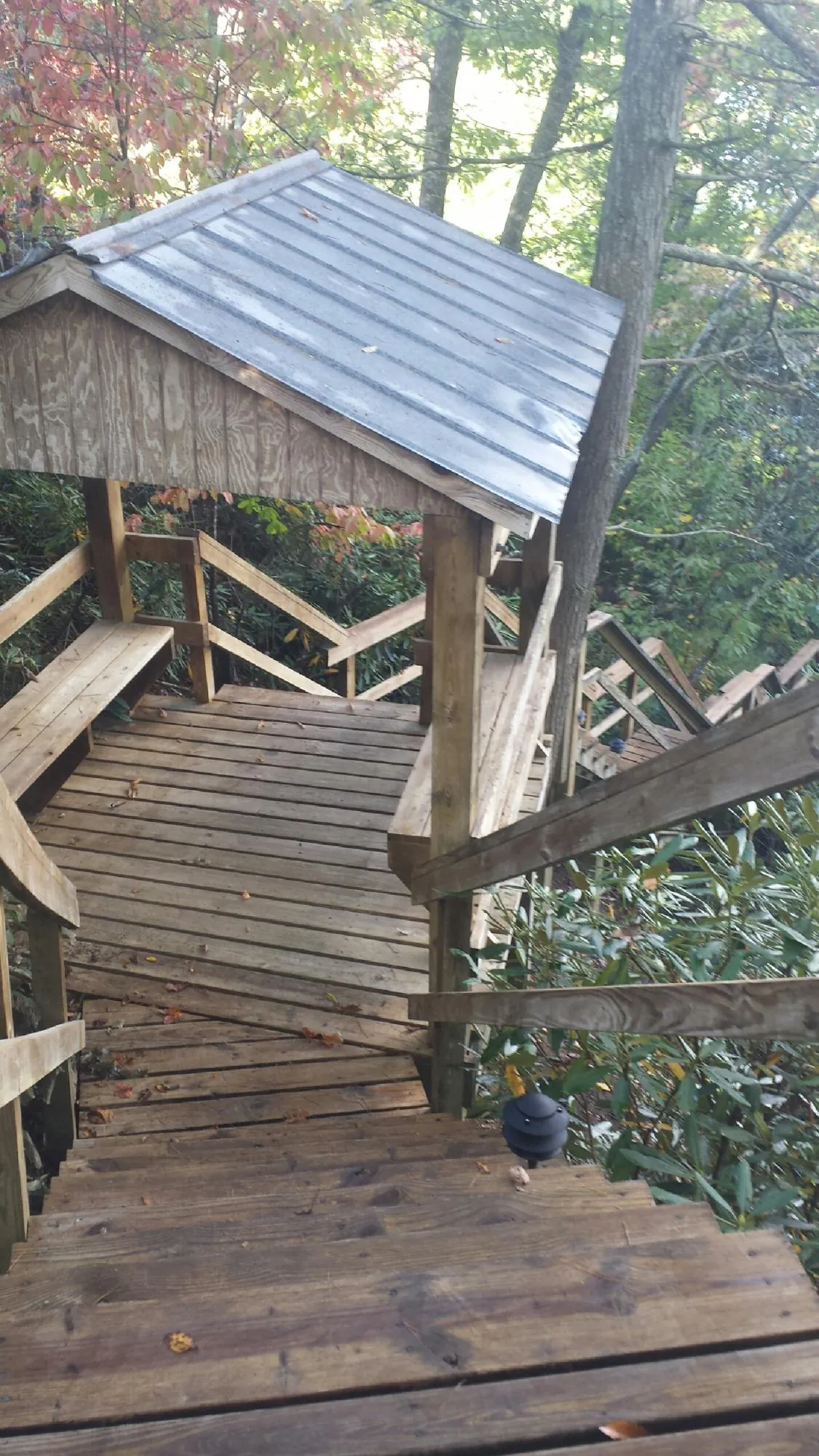 Metal roofed shelter over wooden steps on a wooded walkway — Skylight Repair & Installation work by our crew in Kawkawlin